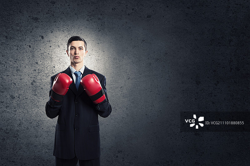 他准备好为成功而战：戴拳击手套的年轻商人图片素材