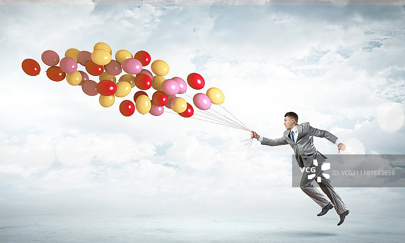 手拿气球的商人：快乐的商人拿着一束彩色气球奔跑图片素材