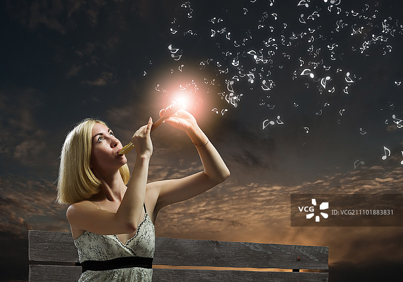 坐在长椅上吹笛子的女人图片素材