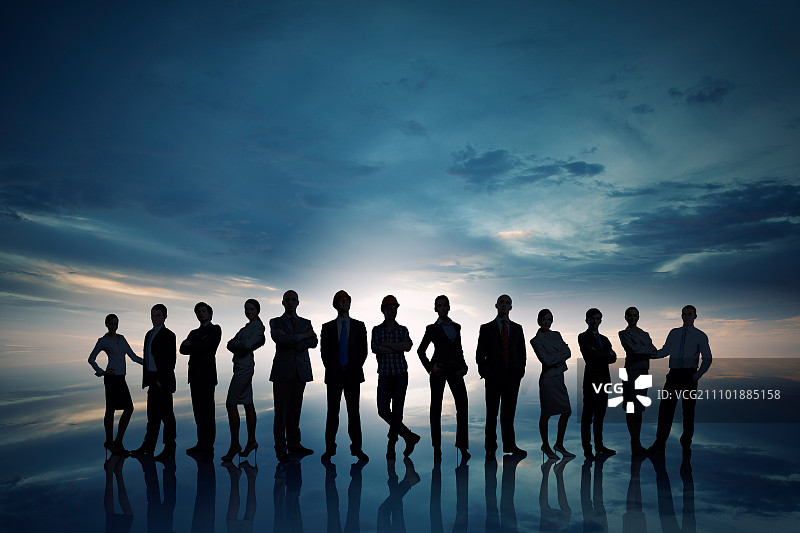 夕阳背景下排队站立的商务人士剪影图片素材