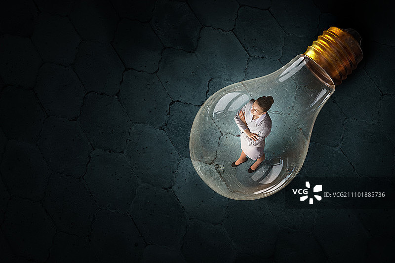 在想法中的女人。在玻璃灯泡里冥思苦想的女商人，头脑风暴概念图片素材