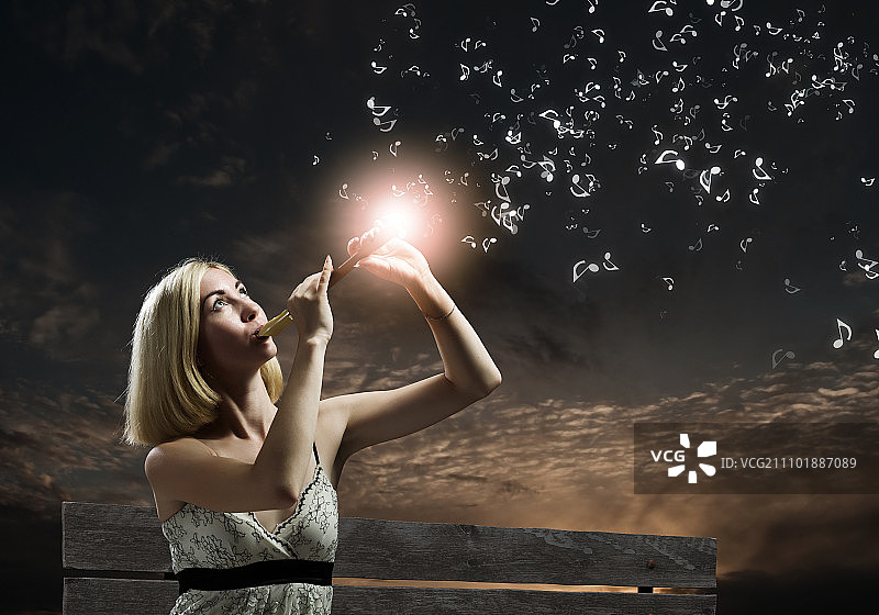 坐在长椅上吹笛子的女人图片素材