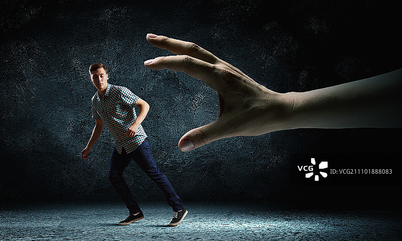 男子逃跑的搞笑图片，试图从巨手中逃脱图片素材