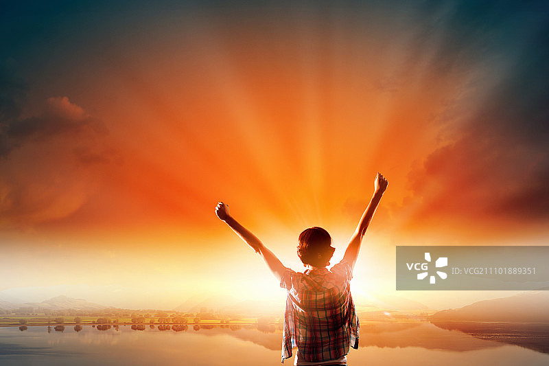 面朝新的一天：快乐的女子双手举起，面朝日出图片素材