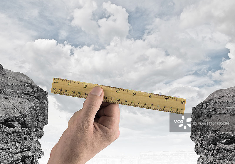 评估风险：用尺子测量间隙的人手特写图片素材