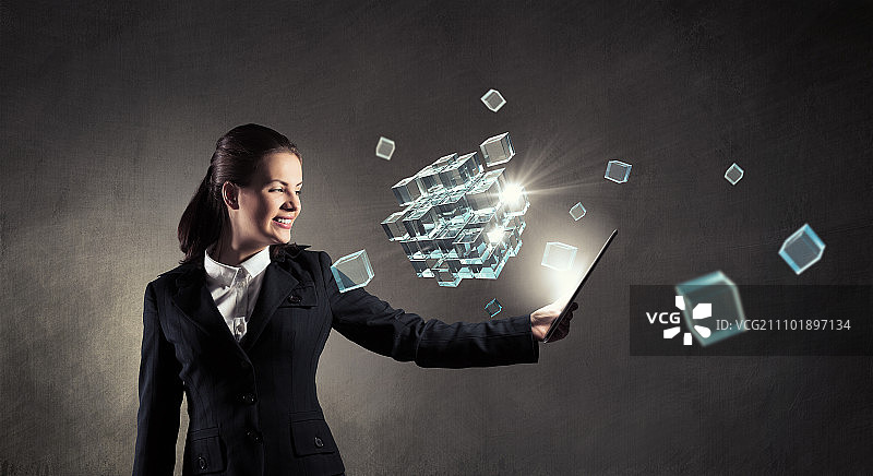 拿着平板电脑的女人。年轻女商人拿着平板电脑在黑暗背景下图片素材