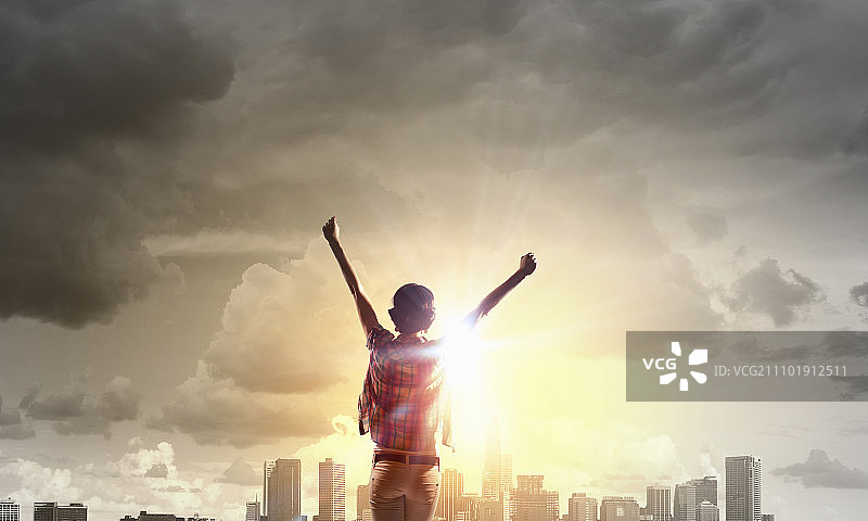 面朝新的一天：快乐的女子双手举起，面朝日出图片素材