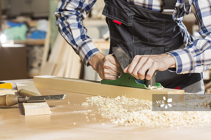 木匠在工作室用刨子工作的双手特写图片素材