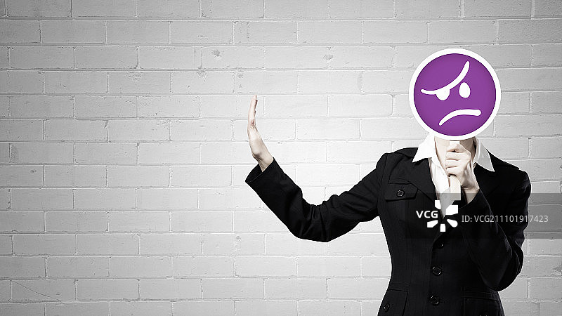 女人的面具。女商人把她的脸藏在面具后面，并做出停止的手势图片素材
