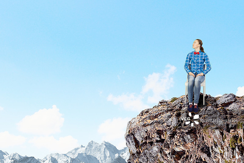 隔离概念：坐在岩石上的年轻女子图片素材