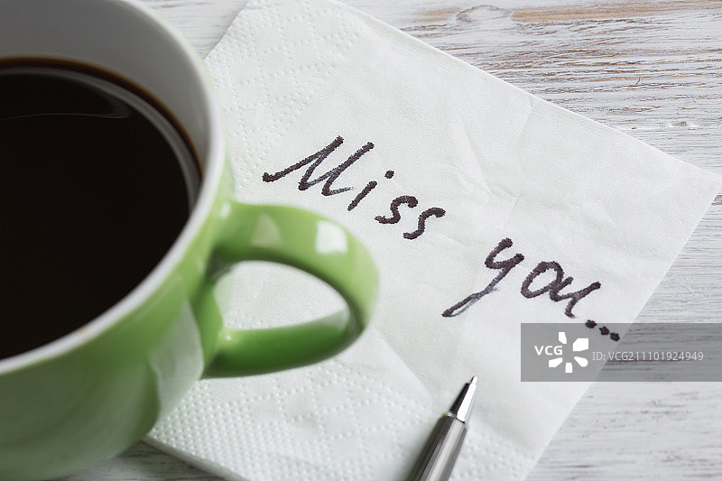 餐巾纸上的爱情告白。写在餐巾纸上的浪漫留言和木桌上的咖啡杯图片素材