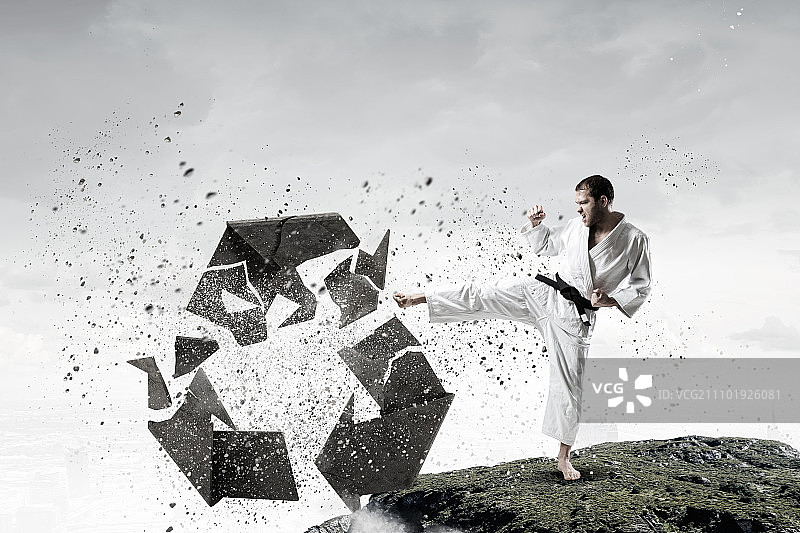 空手道男子跳跃击碎石头的场景图片素材