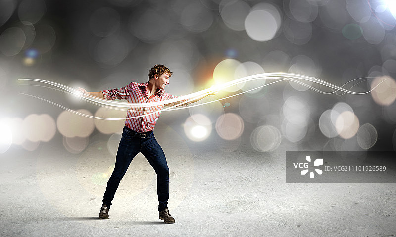 男魔术师：用魔法之光的年轻男子图片素材