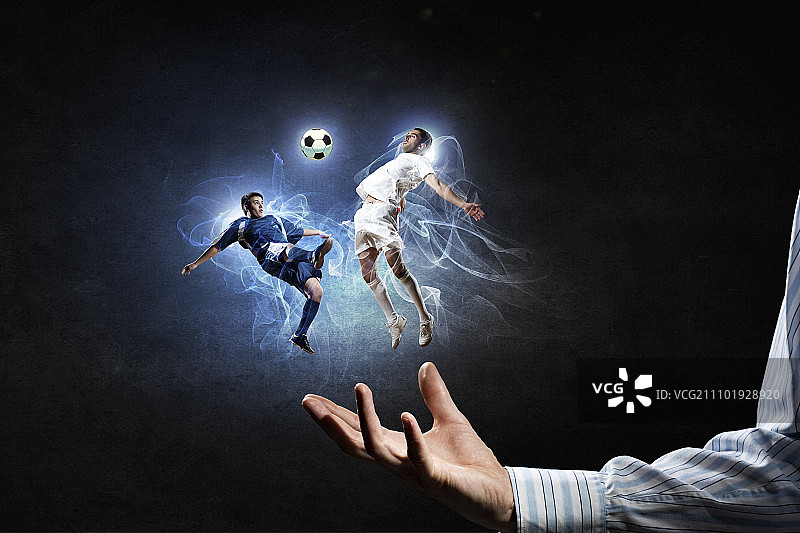 足球运动员争球，两名足球运动员在男性手掌中拼抢图片素材