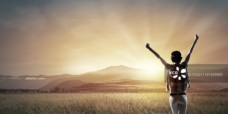 面朝新的一天：快乐的女子双手举起，面朝日出图片素材