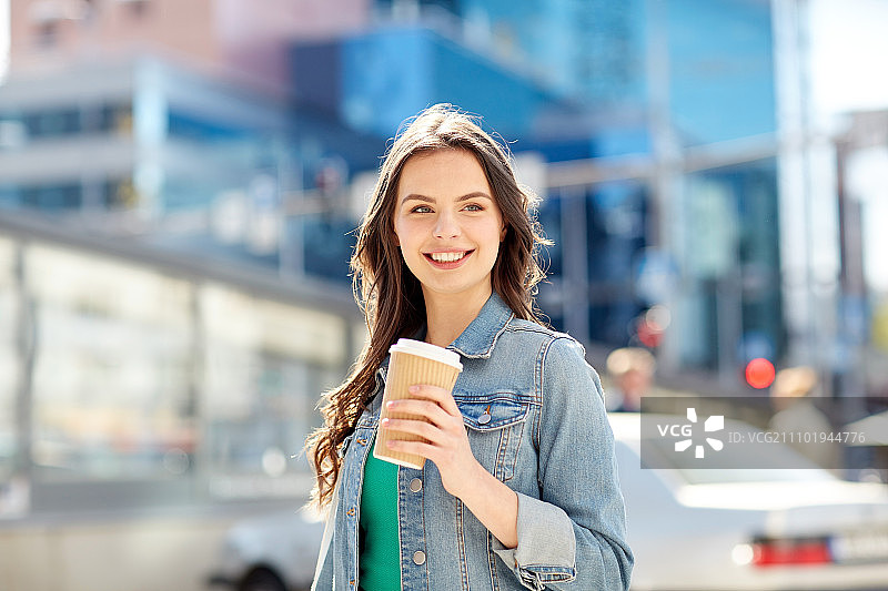 饮品与人物概念-在城市街道上用纸杯喝咖啡的快乐年轻女子或少女图片素材