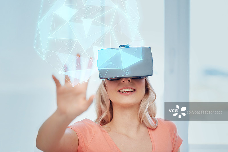 增强现实技术：佩戴3D眼镜的年轻女子在家中玩游戏，观看虚拟低多边形投影图片素材