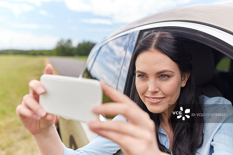 夏季假期、旅行、公路旅行：年轻女子开车自拍或录制视频图片素材