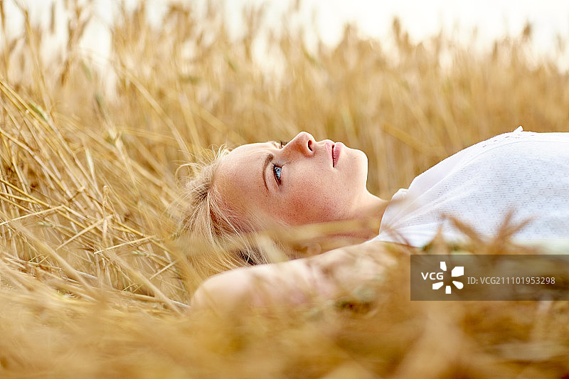 夏日：年轻女子在麦田上做梦图片素材