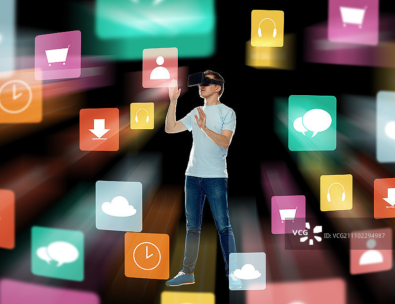 3D技术，增强现实，游戏，网络空间和人物概念 - 戴着虚拟现实头显或3D眼镜的快乐年轻人，黑色背景上带有菜单图标图片素材