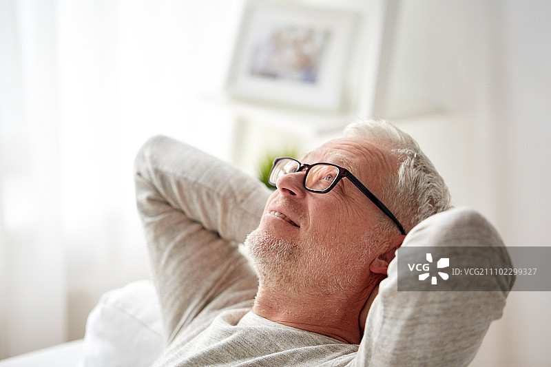 老年人在家放松的概念——在沙发上放松的微笑老人图片素材