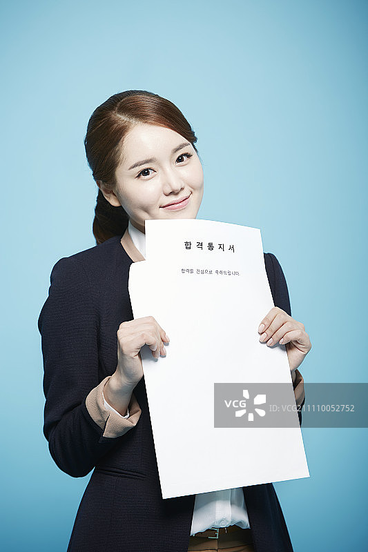 女人拿着工作邀请函，面带微笑图片素材