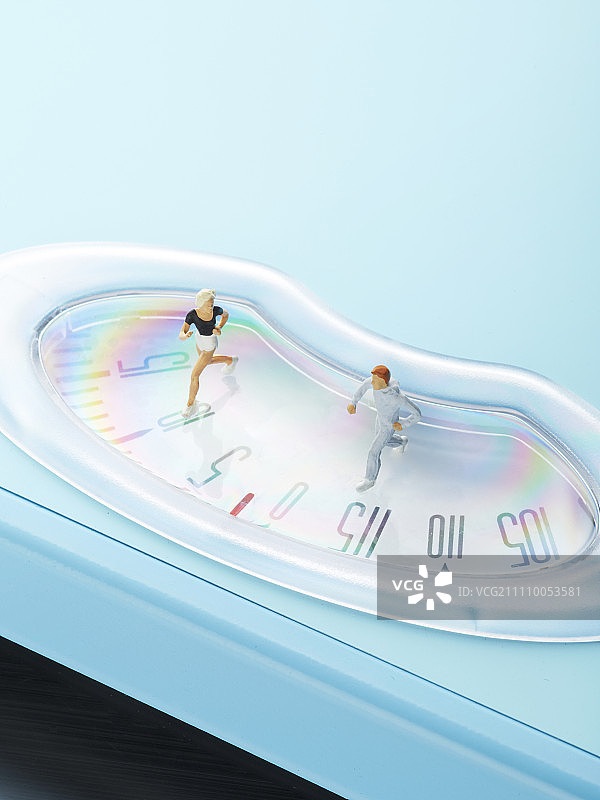 在体重秤上跑步的微型人形图片素材