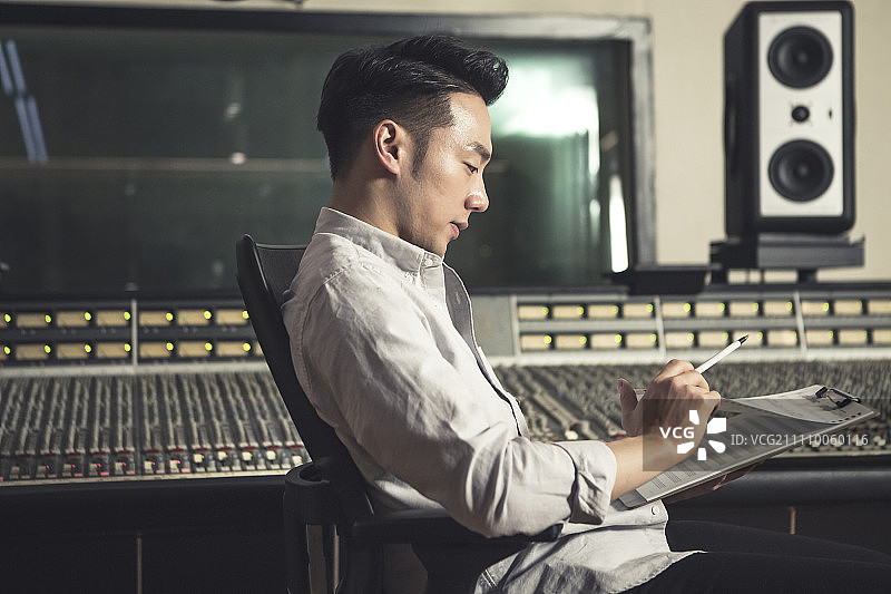 音乐制作人翻阅乐谱图片素材