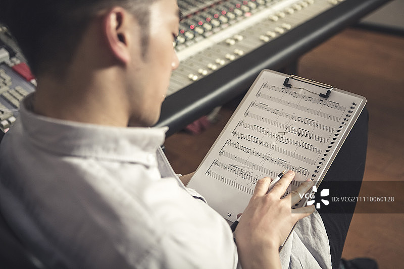 男人在乐谱上写笔记图片素材