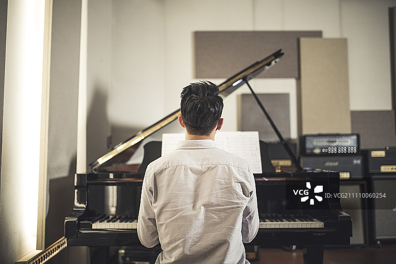 弹钢琴的男人，后视图图片素材