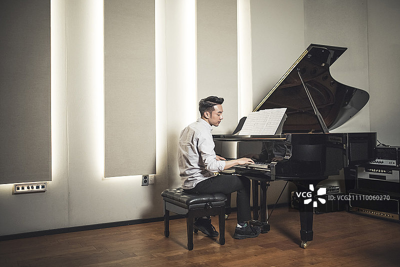 男人在工作室弹钢琴图片素材