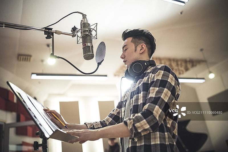 男子在录音棚的麦克风前图片素材