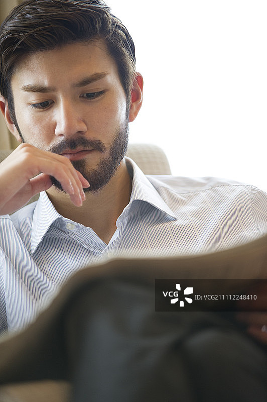 男人在沙发上看书图片素材