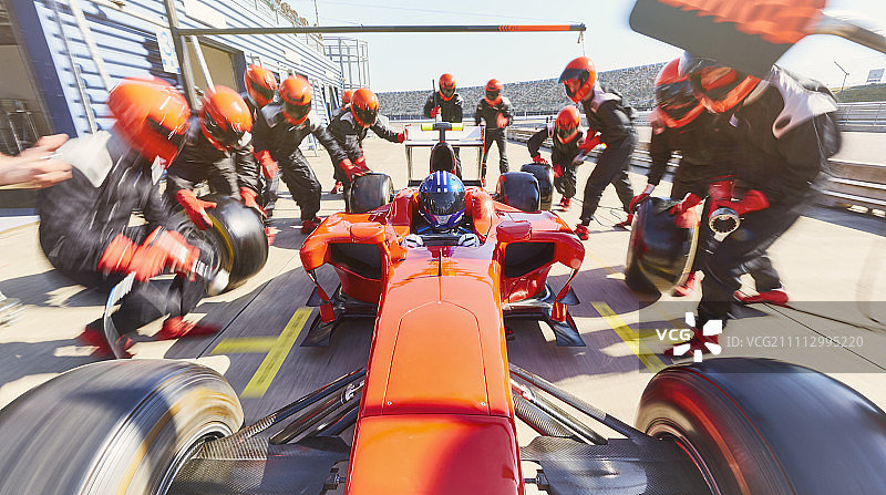 维修站工作人员更换一级方程式赛车轮胎图片素材