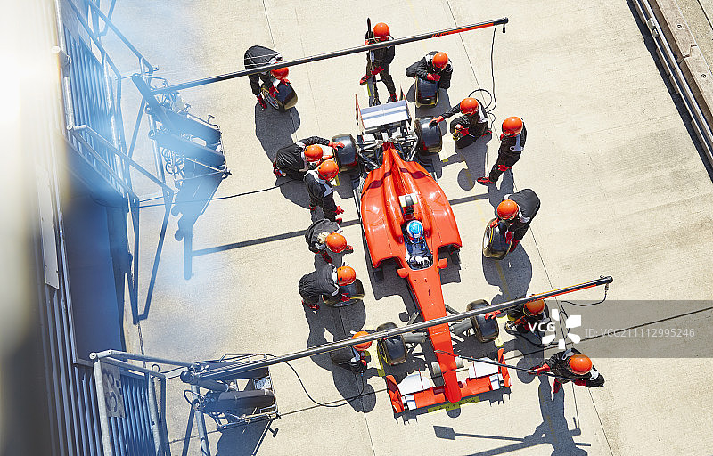 维修站工作人员更换一级方程式赛车轮胎的俯视照片图片素材