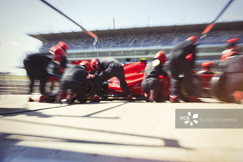 维修站工作人员更换一级方程式赛车轮胎图片素材