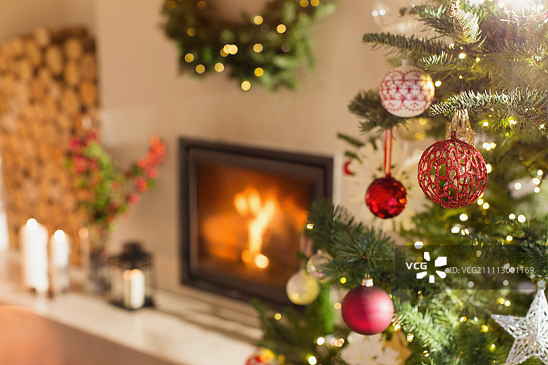 壁炉旁圣诞树上悬挂的红白色装饰品图片素材
