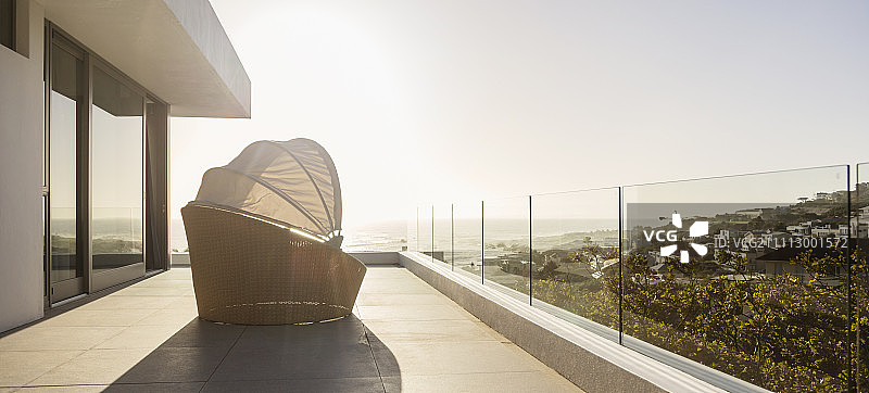 阳光明媚的豪华阳台上带遮盖的躺椅图片素材