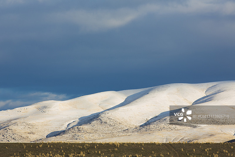 苦根山脉在晚秋阳光照耀下的白雪覆盖的山坡图片素材