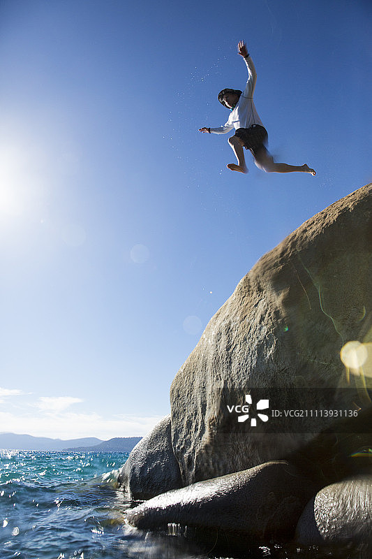男子在沙港州立公园跳入河中岩石图片素材