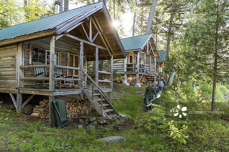 两名男子在缅因州格林维尔附近阿巴拉契亚山俱乐部的戈尔曼小屋旁搬运独木舟图片素材