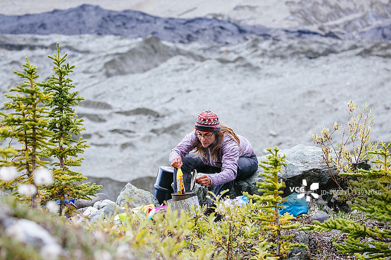 在美国阿拉斯加州Root冰川营地准备晚餐的女人图片素材