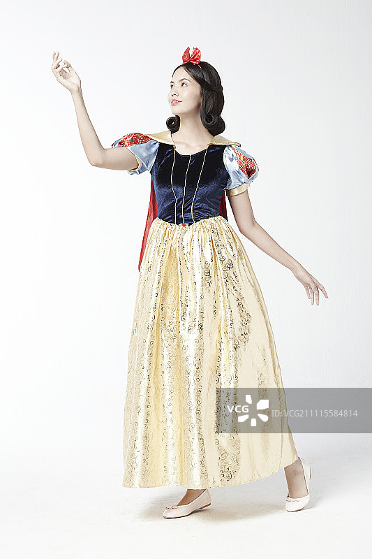 穿着白雪公主服装在影棚摆姿势的女人图片素材