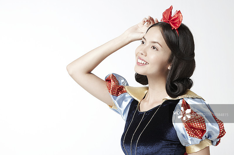 穿着白雪公主服装在影棚摆姿势的女人图片素材