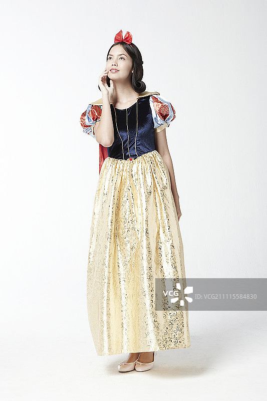 穿着白雪公主服装在影棚摆姿势的女人图片素材