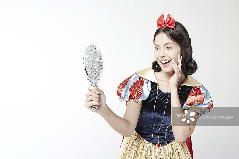 身穿白雪公主服装的女人照镜子图片素材