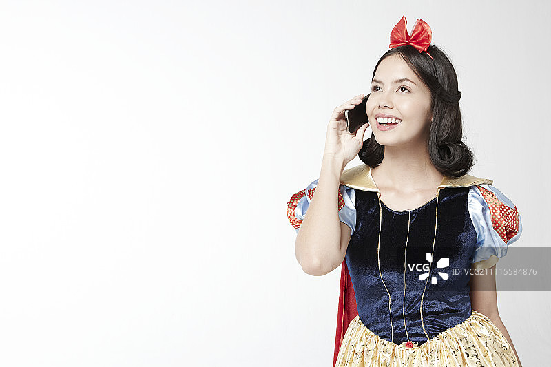 身穿白雪公主服装的女人使用智能手机图片素材