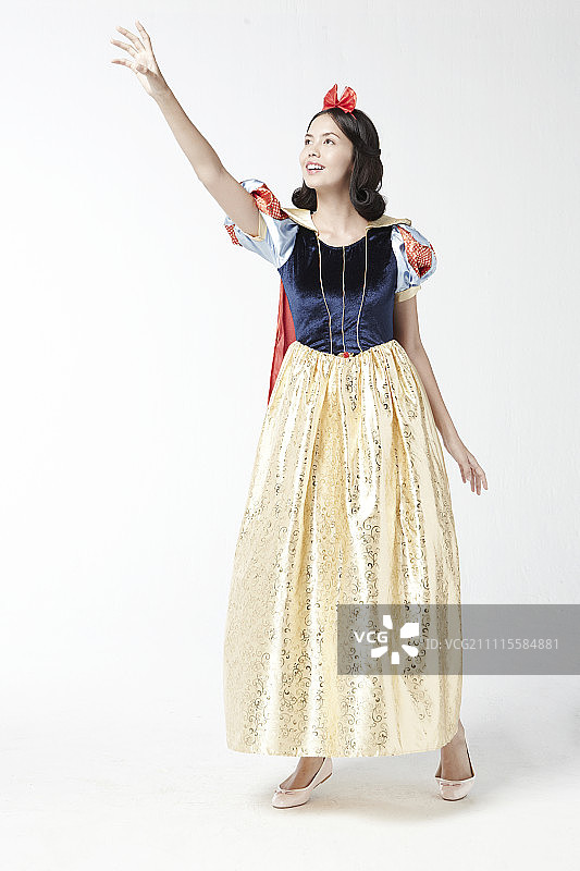 穿着白雪公主服装在影棚摆姿势的女人图片素材