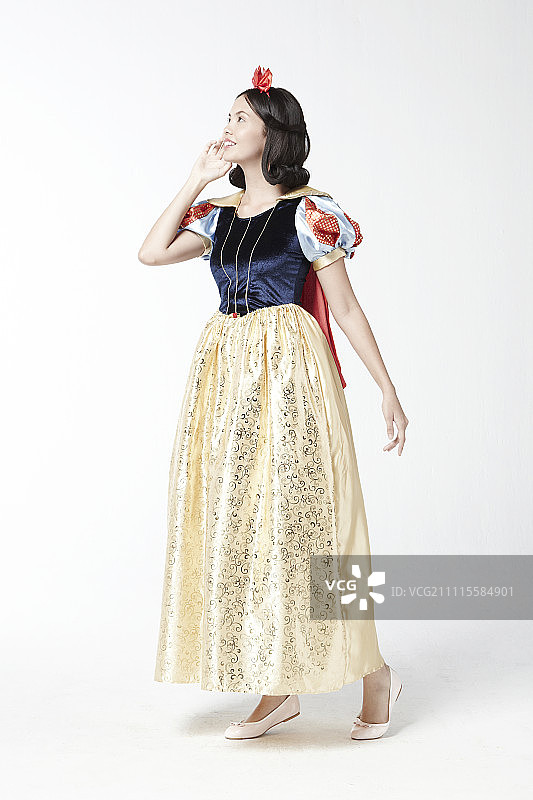 穿着白雪公主服装在影棚摆姿势的女人图片素材