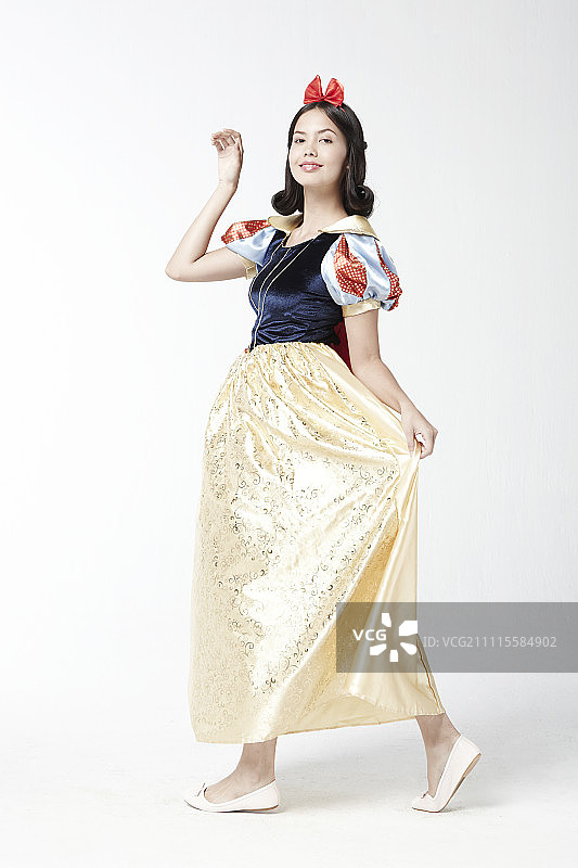 穿着白雪公主服装在影棚摆姿势的女人图片素材